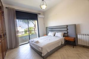 a bedroom with a bed and a large window at Villa avec piscine 4 chambres proche CFC & tramway Casablanca in Casablanca +36 photos