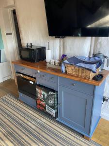 Un mostrador con un microondas y un televisor encima. en The Wendy house, en Parkend
