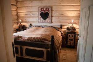 Un dormitorio con una cama con una pared de madera. en Nydelig hyttetun på Torpoåsen, en Torpo