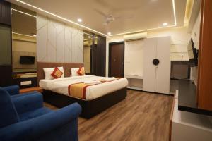 a hotel room with a bed and a blue couch at Hotel Sunrise N Resorts in Nagpur