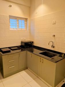 マイソールにあるSihi Homesのシンクとカウンタートップのあるキッチン