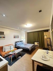 a hotel room with a bed and a couch at Gramercy Makati Condotel in Manila +62 photos