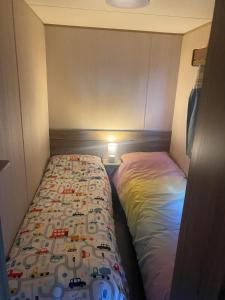a small bed in a small room with a bedsheet at Lapwing Lea 16, Thornwick Bay in Flamborough