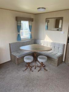 a living room with a table and a couch at Lapwing Lea 16, Thornwick Bay in Flamborough
