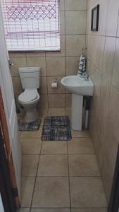 a bathroom with a toilet and a sink at NEMARA Self Catering Lodge in Polokwane +14 photos