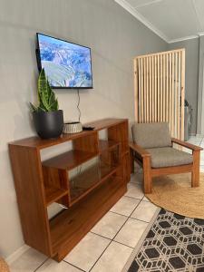 a living room with a tv and a chair at Lang Apartment in Great Brak River