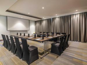 a conference room with a long table and chairs at Novotel Vijayawada Varun in Vijayawāda +96 photos