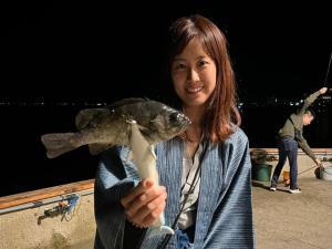 a woman holding a fish in her hand at Awakan in Sumoto
