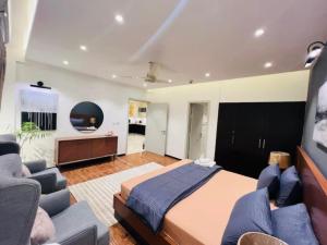 a bedroom with a bed and a couch and a tv at Luxury 1 BHK Family Apartment in Bahria Town, Islamabad in Rawalpindi