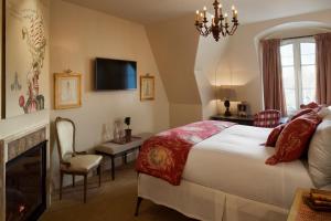 una camera con letto, camino e TV di Enchante Boutique Hotel a Los Altos