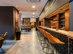 a bar in a restaurant with orange chairs at ibis Styles Bamberg in Bamberg