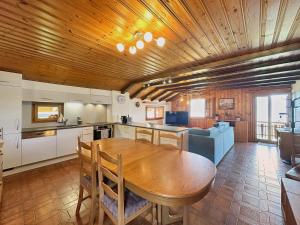 a kitchen and dining room with a wooden ceiling at Bear Ridge Retreat - 8mns to slopes - Swiss Alps in Agettes