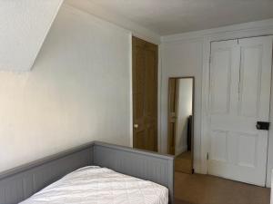 - une chambre vide avec un lit et une porte dans l'établissement Spacious Cosy 2 Bed Flat in The Heart of Headingley, à Headingley