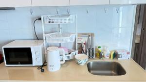 a kitchen counter with a microwave and a sink at Artisan Ratchada Condo Bangkok in Bangkok +78 photos