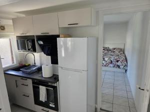 a kitchen with a white refrigerator and a bed at Cozy 29 m appartement in Fresnes