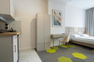 a bedroom with a bed and a desk and a chair at Moon ApartHotel in Wrocław