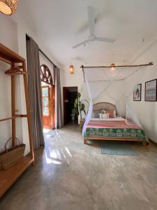 a bedroom with a bed with a mosquito net at La Sirena Villa in Unawatuna