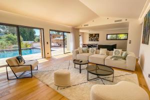 a living room with a couch and chairs and a pool at Villa A Calia di Fiori Mare in Sainte-Lucie de Porto-Vecchio