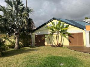 une maison avec deux palmiers et un garage dans l'établissement Villa Stella Australis 4 étoiles, à Petite Île