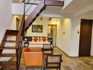 a bedroom with a staircase and a bed with an orange chair at HALF Hotel, Calangute in Calangute +54 photos