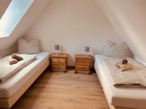 two twin beds in a room with two night stands at Ferienwohnung Hotel Preyt in Holtland