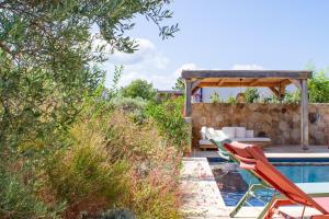 a pool with two lawn chairs and a pergola at Villa A Calia di Fiori Mare in Sainte-Lucie de Porto-Vecchio