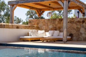 a patio with a couch and a table next to a pool at Villa A Calia di Fiori Mare in Sainte-Lucie de Porto-Vecchio