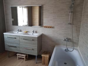 a bathroom with a sink and a tub and a mirror at Gîte Le Lac à La Dame in Foncine-le-Bas +6 photos