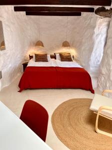une chambre avec un grand lit avec une couverture rouge dans l'établissement Finca Antigua, à Las Breñas