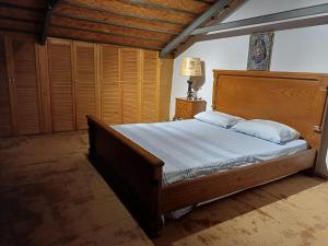 a bedroom with a large bed with a wooden headboard at ANTALYA KALEİÇİ ÖZEL MÜSTAKİL BAHÇELİ VİLLa in Antalya