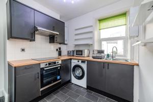 a kitchen with a washing machine and a sink at Eastbourne 2 Bedroom Apartment Next to Shopping Centre and Beach in Eastbourne