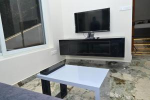 a white bench in a room with a flat screen tv at Bluevalley Estate - Three Bedroom Villa in Yercaud +39 photos
