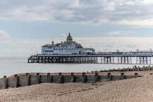 a pier with a building in the water at Eastbourne 2 Bedroom Apartment Next to Shopping Centre and Beach in Eastbourne