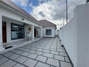 a white house with a tiled walkway at Dachu Urban Homes in Dar es Salaam