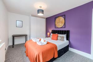 a bedroom with a bed with an orange blanket at Eastbourne 2 Bedroom Apartment Next to Shopping Centre and Beach in Eastbourne