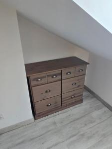 a wooden dresser in the corner of a room at Charmant 2 pièces au cœur de Vendôme in Vendôme