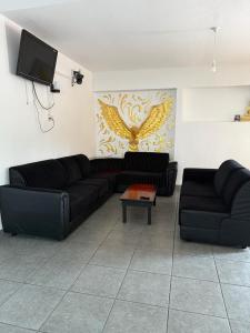 a living room with two black couches and a tv at Sonthos Hotel in Nuwara Eliya +17 photos