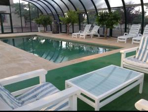 a pool with lounge chairs and a table next to it at Finca el descanso manchego in Fuente de Pedro Naharro