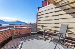 a patio with two chairs and a table on a building at Fjord and Mountain View in Tromsø