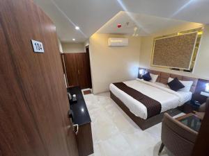 a hotel room with a bed and a sliding door at The Hotel Sundaram Continental in Prayagraj