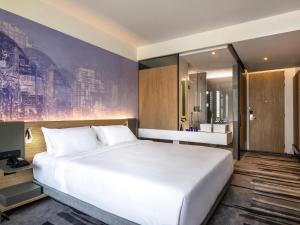a bedroom with a large white bed and a mirror at Novotel Bangkok Sukhumvit 4 in Bangkok +54 photos