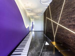 a hallway with a purple wall and a staircase at Ibis Styles Merida Galerias in Mérida