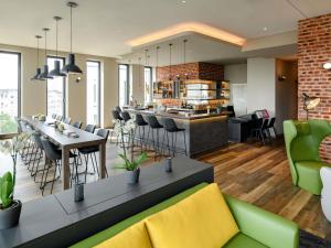 a restaurant with a bar with chairs and tables at Aparthotel Adagio Bremen City in Bremen +88 photos