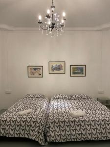 une chambre avec deux lits et un lustre dans l'établissement Guest House & Homestay "Feel at Home" Near A Famosa Fortress & Stadhuys, à Malacca