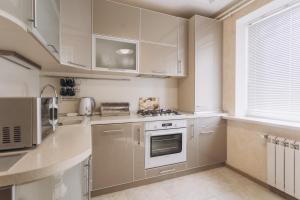 スームィにあるIllinska 2 rooms apartmentsのキッチン(ステンレス製の電化製品、白いキャビネット付)