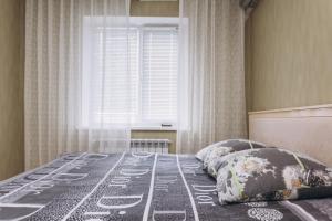 スームィにあるIllinska 2 rooms apartmentsの大きな窓のあるベッドのある寝室