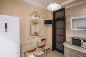 スームィにあるIllinska 2 rooms apartmentsのキッチン(テーブル、椅子、電子レンジ付)