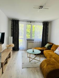 un soggiorno con un divano e un tavolo di Apartament a Tarnowskie Góry