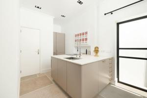 a white kitchen with a sink and a window at Lagoa Vacation Home in Lagoa