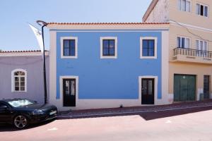 a black car parked in front of a blue house at Lagoa Vacation Home in Lagoa